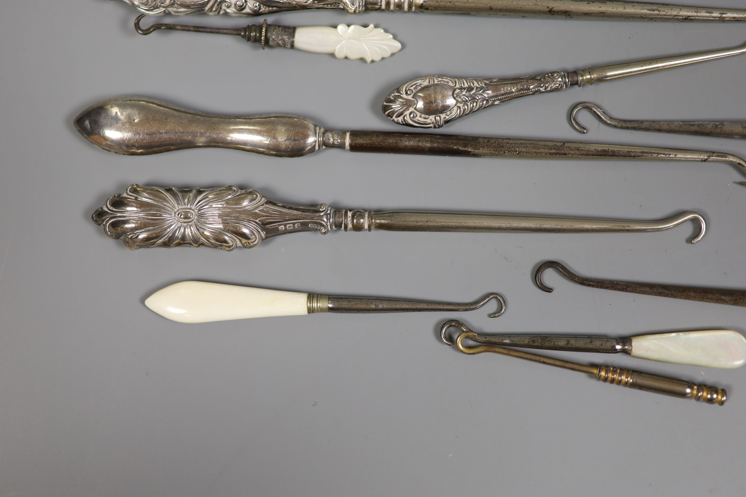 A collection of assorted silver handle button hooks and a nail implement.